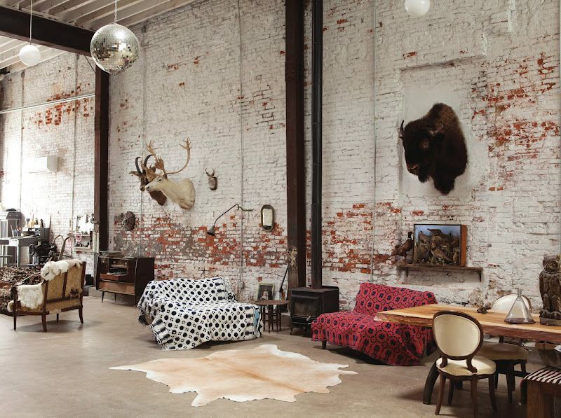 Представьте квартиру, где нет классических стен, вместо люстры — открытые лампочки на проводе, а бетонный потолок не скрыт под слоем гипсокартона. Это не недоремонт — это ремонт в стиле лофт, где главной ценностью становится не идеальность, а характер пространства. Ведь здесь речь не о дизайне ради картинки, а о философии жизни. Если вам хочется выйти за пределы «евроремонта» и дать волю архитектурной искренности — вы уже на полпути к лофту.
Что такое лофт на самом деле?
Слово loft — английского происхождения, которое сначала обозначало чердачное или промышленное помещение. А уже с 40-х годов прошлого века в Нью-Йорке его начали использовать как термин для просторов, превращенных из складов и фабрик в жилье. Без перегородок, с высокими потолками, трубами, вентиляцией, большими окнами — все это не прятали, а наоборот, подчеркивали. С тех пор ремонт в стиле лофт эволюционировал от вынужденного решения для бедных художников к желаемому выбору людей, которые ценят смысл, а не блеск.
Почему выбирают лофт?
Стиль лофт не фальшивит. Здесь кирпич — настоящий, балки — опорные, а металл — тяжелый. В мире, где все «под что-то», лофт — редкая честность. Ремонт квартиры в стиле лофт выбирают те, кто не хочет загроможденного пространства, ценит функциональность и свободу в быту. Это не стиль о «хорошо», а о «живой энергии». Лофт не боится возраста, царапин, открытой проводки или старого стула. Он только с годами становится лучше, как джинсы или дубовый стол.
Также это и о рациональности. Представьте: не нужно прятать трубы или выравнивать каждую стену. Бюджетный ремонт в стиле лофт — это не оксюморон, а вполне реальная история. Он позволяет сэкономить на облицовке, при этом не выглядя дешево.
Кому нравится лофт?
Этот стиль чаще всего выбирают:
●	творческие люди — художники, музыканты, архитекторы и фотографы;
●	айтишники и фрилансеры, которые хотят не сковывающее пространство;
●	молодые пары — потому что это небанально;
●	те, кто не признает стандарты.
Это, конечно, обобщение. Но суть в том, что ремонт в стиле лофт своими руками часто делают люди, которым просто хочется больше воздуха, меньше условностей и простора для жизни, а не для обывательского «как у всех».
Основные черты стиля
1.	Пространство. Минимум перегородок и максимум объема. Кухня перетекает в гостиную, а ванная — часть спальни. Лофт не признает ограничений.
2.	Фактура. Кирпич, бетон, дерево и металл. Причем все аутентичное, грубое, не отполированное до блеска. Иногда материал даже специально «состаривают».
3.	Цветовая палитра. Серый, графитовый, черный, белый, иногда охра или рыжий, как ржавый металл. Это сдержанные оттенки, но при этом цепляющие и удерживающие внимание.
4.	Мебель. Минимум предметов, максимум содержания. Часто — винтаж или переработанные вещи: стол из старой доски, стеллаж из стальных труб или лампа из фабричного плафона.
5.	Освещение. Это ключевая деталь. Многоуровневое, точечное, на шинопроводах или тросах. Свет подчеркивает форму, а не только освещает уголки.
Почему это действительно классный выбор?
Потому что лофт — адаптивный. В нем легко менять что-либо: переставить мебель, по-другому зонировать пространство, добавить акцентный цвет. Все выглядит уместно, даже если это неожиданное решение. Такой стиль не стареет — он вне моды. Ремонт в стиле лофт одинаково уместен в центре Киева, на мансарде во Львове или в доме на опушке.
К тому же он прощает «неидеальность». Если вы решили сделать ремонт в стиле лофт своими руками, совсем не обязательно быть профессиональным дизайнером. Это как игра в конструктор: главное — видеть целостную картину. Используйте старую мебель, откройте трубы, сделайте полку из доски и шлакоблока — и у вас уже есть первые элементы лофта.
А что с бюджетом?
Есть мнение, что это дорого. Но все довольно гибко: можно сделать и бюджетный ремонт в стиле лофт, если использовать простые материалы, минимизировать отделку и создавать интерьер постепенно. Бетонный пол + светлые стены + несколько дизайнерских акцентов — и уже есть характер. Кстати, именно с конкретным бюджетом лофт часто и срабатывает. Ибо в условиях ограниченных средств лучше честный кирпич, чем псевдо-барокко с гипсовыми карнизами. И именно здесь уместна формула: меньше — значит больше.
Минусы — без розовых очков
Да, лофт – не для всех. Есть некоторые нюансы:
1.	Акустика. Открытые пространства создают эффект эха. Если у вас есть дети или громкие хобби — подумайте о звукопоглощении.
2.	Теплоизоляция. Большие окна и бетонные стены — красиво, но они требуют качественного утепления. Иначе зимой будет холодно.
3.	Не каждый дом подходит. Иногда следует бороться с опорными стенами, низкими потолками или коммуникациями. В новостройках сделать настоящий лофт сложнее, чем в старом промышленном здании.
4.	Бдительность к деталям. Чтобы лофт не выглядел как недоделанный ремонт, нужно хорошо продумать композицию. Иначе вместо «индустриального стиля» выйдет просто хаос.
Как реализовать своими руками?
1.	Начните с планирования. Нарисуйте схему зоны: где будет кухня, рабочее место и спальная часть. Оставляйте максимум открытого пространства.
2.	Определитесь с цветами и фактурами. Не используйте более 3–4 материалов одновременно.
3.	Обратите внимание на освещение. Оно может либо «вытянуть» весь интерьер, либо свести на нет даже удачные решения.
4.	Работайте постепенно. Лофт не требует мгновенной завершенности — он «растет» с вами. Главное избегать фальши: никаких наклеек «под бетон» или пластика «под дерево».
Итоги без пафоса
Ремонт в стиле лофт — не просто стиль интерьера. Это способ думать и жить. Он отвергает показную роскошь, не гонится за мимолетными трендами и позволяет быть собой. Если вам близка идея свободы, функциональности и ценности вещей с историей — ремонт квартиры в стиле лофт может стать вашим простором силы. И не так и важно, будь то дизайнерский проект или бюджетный ремонт в стиле лофт, сделанный собственноручно — главное, чтобы в нем было место дышать. А еще лучше — чтобы он дышал вместе с вами.
